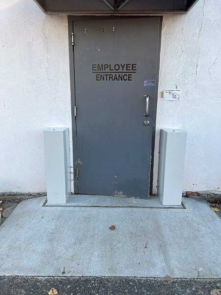 A gray door with the words `` employee entrance '' written on it.