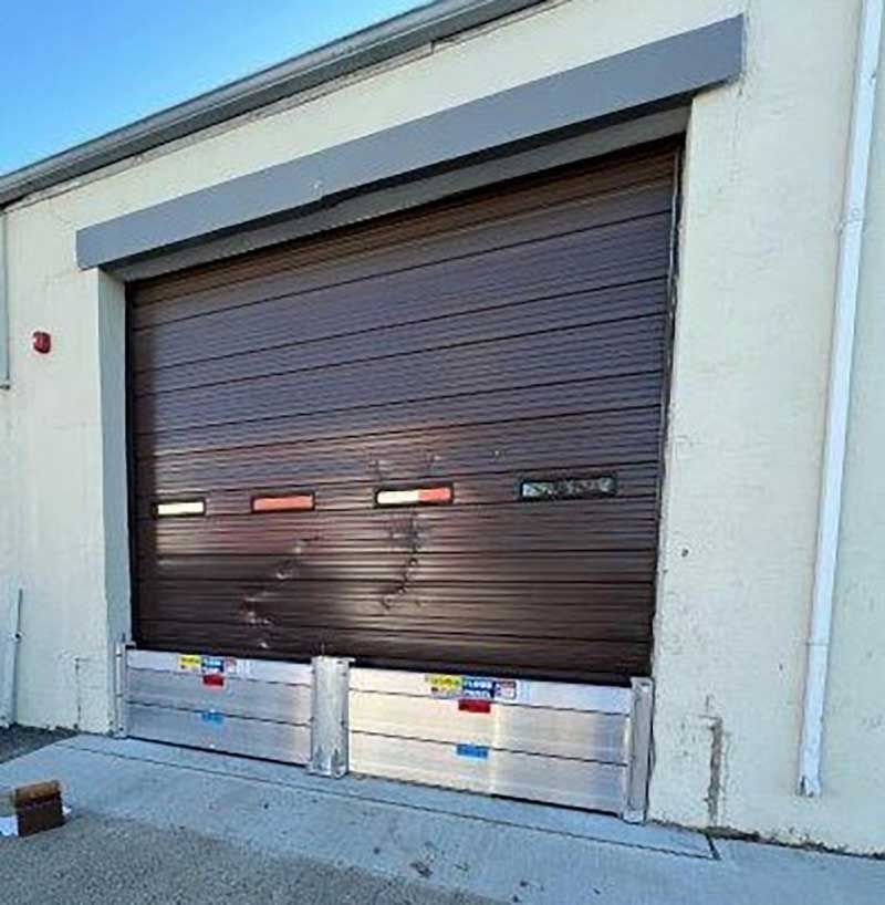 A brown garage door with flood barriers attached to it.