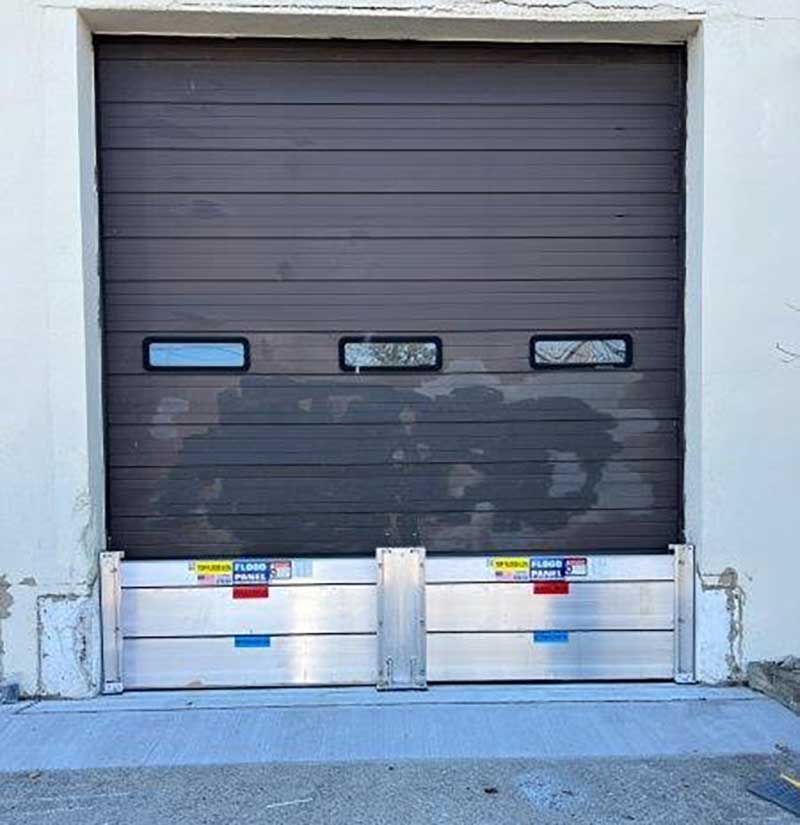 A brown garage door with a flood barrier in front of it