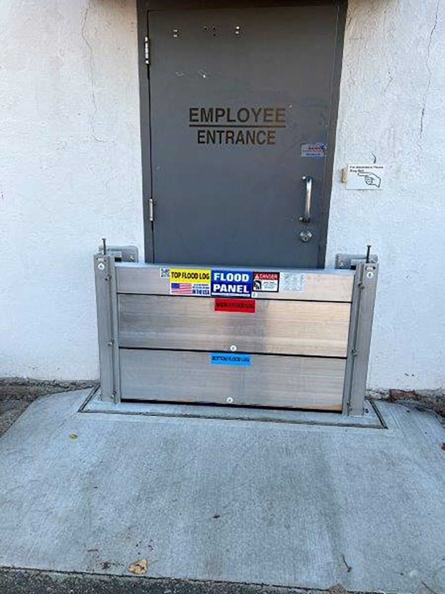An employee entrance door with a flood barrier in front of it.