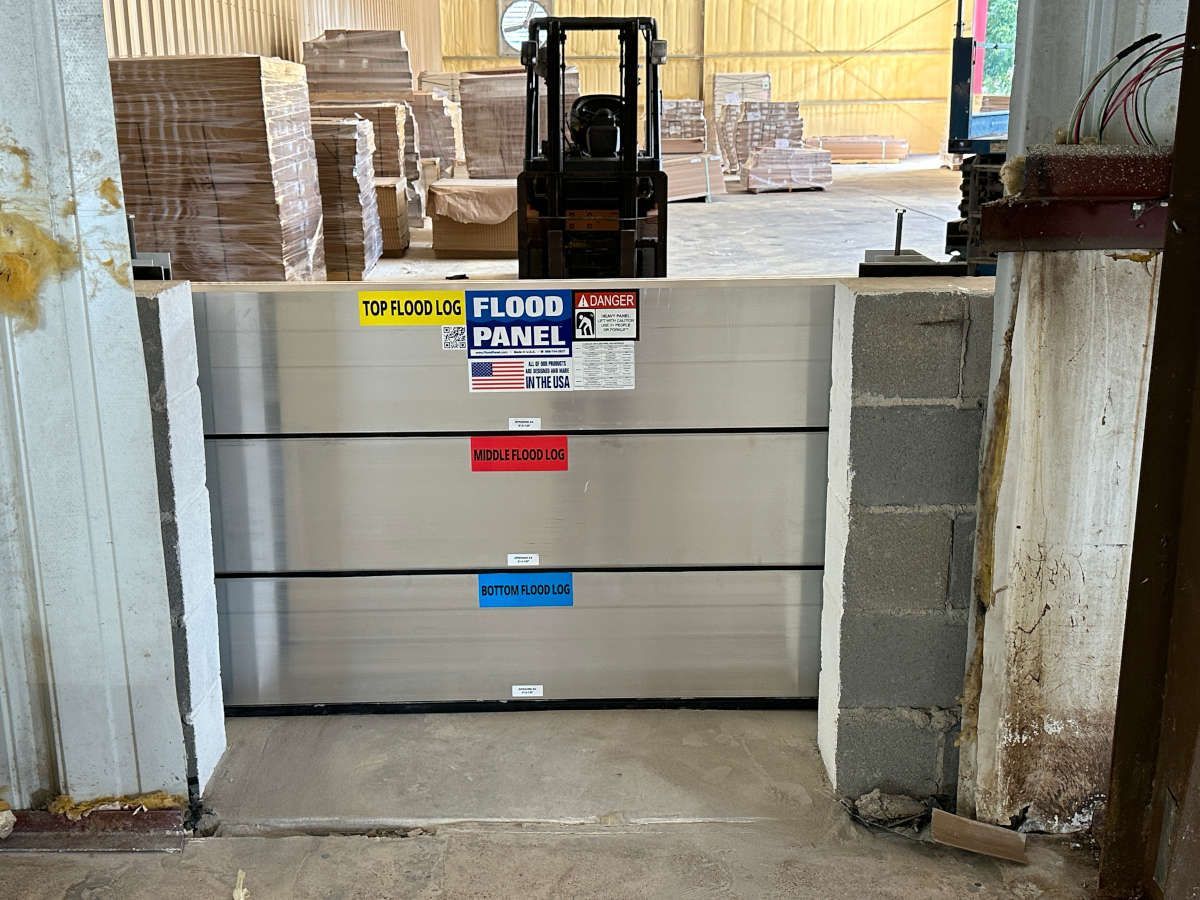 A forklift is driving past a flood panel in a warehouse
