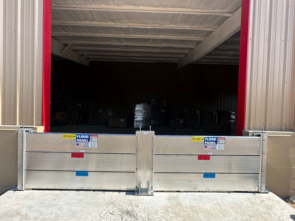 A warehouse with a flood barrier in front of it.