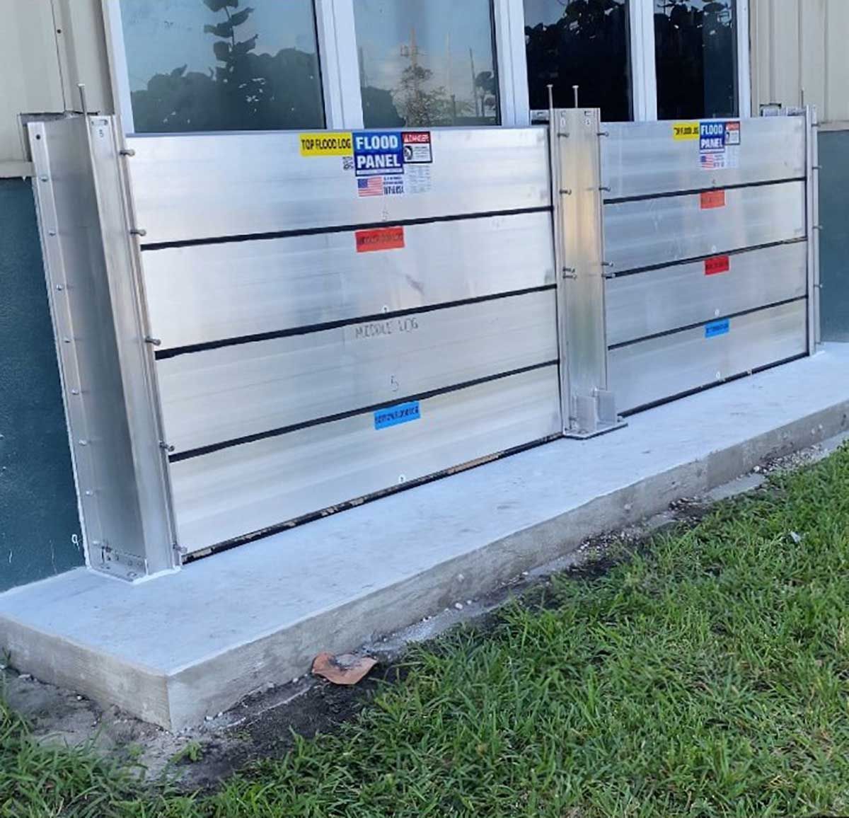 A row of aluminum flood barriers on the side of a building