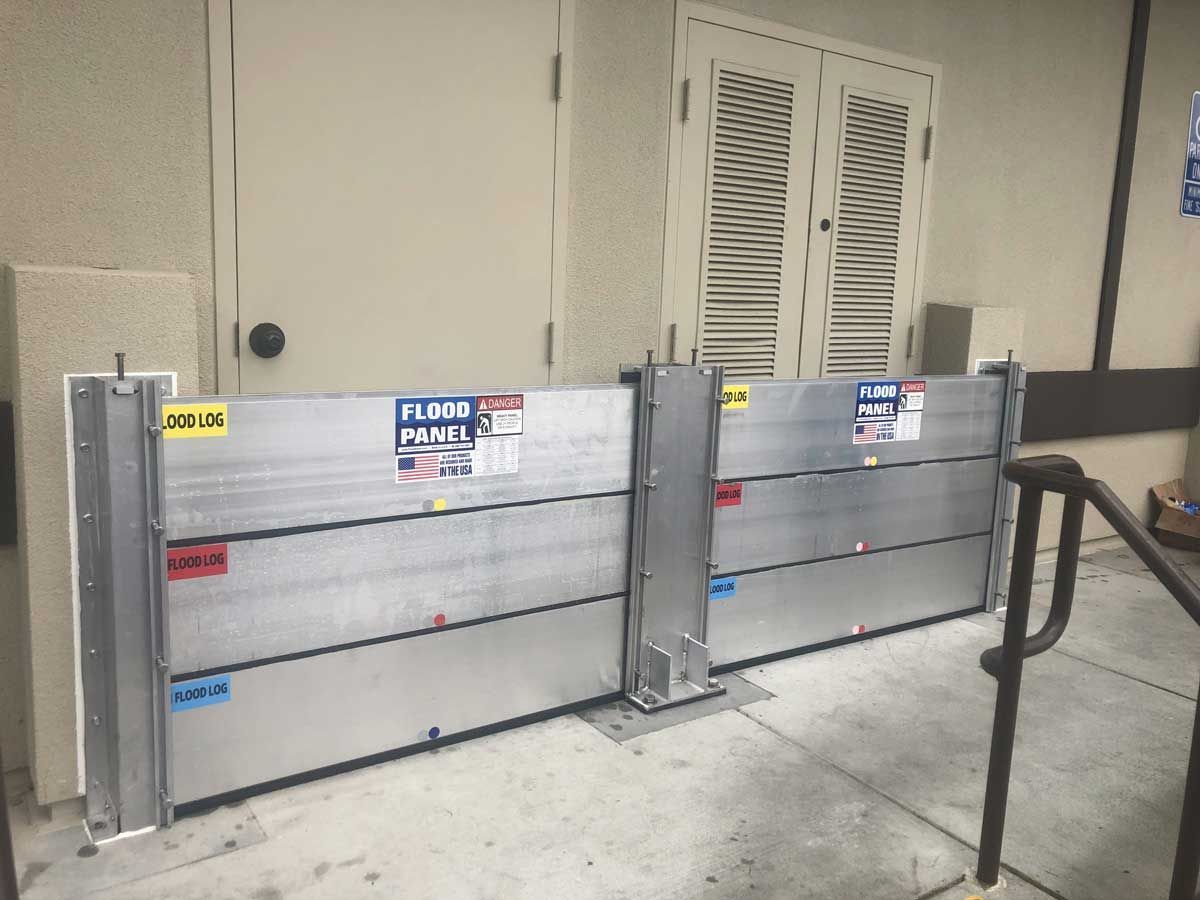 A pair of flood barriers are sitting outside of a building.