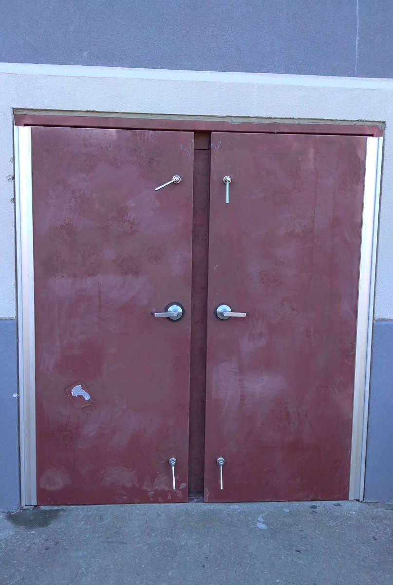 A pair of red doors with silver handles on a building