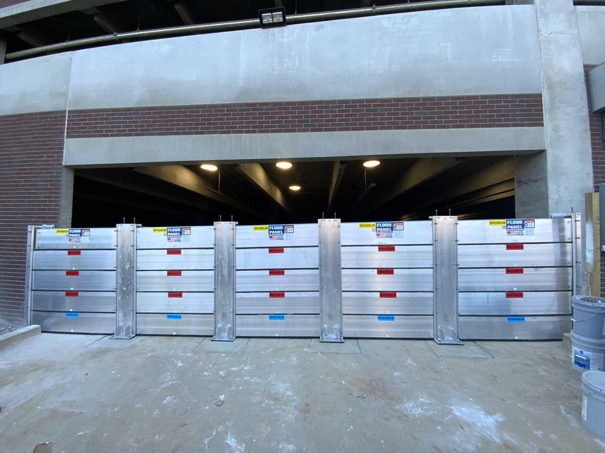 A row of aluminum barriers in front of a brick building