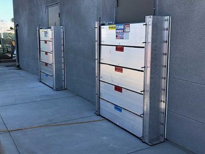 A row of aluminum flood barriers are sitting on the side of a building.