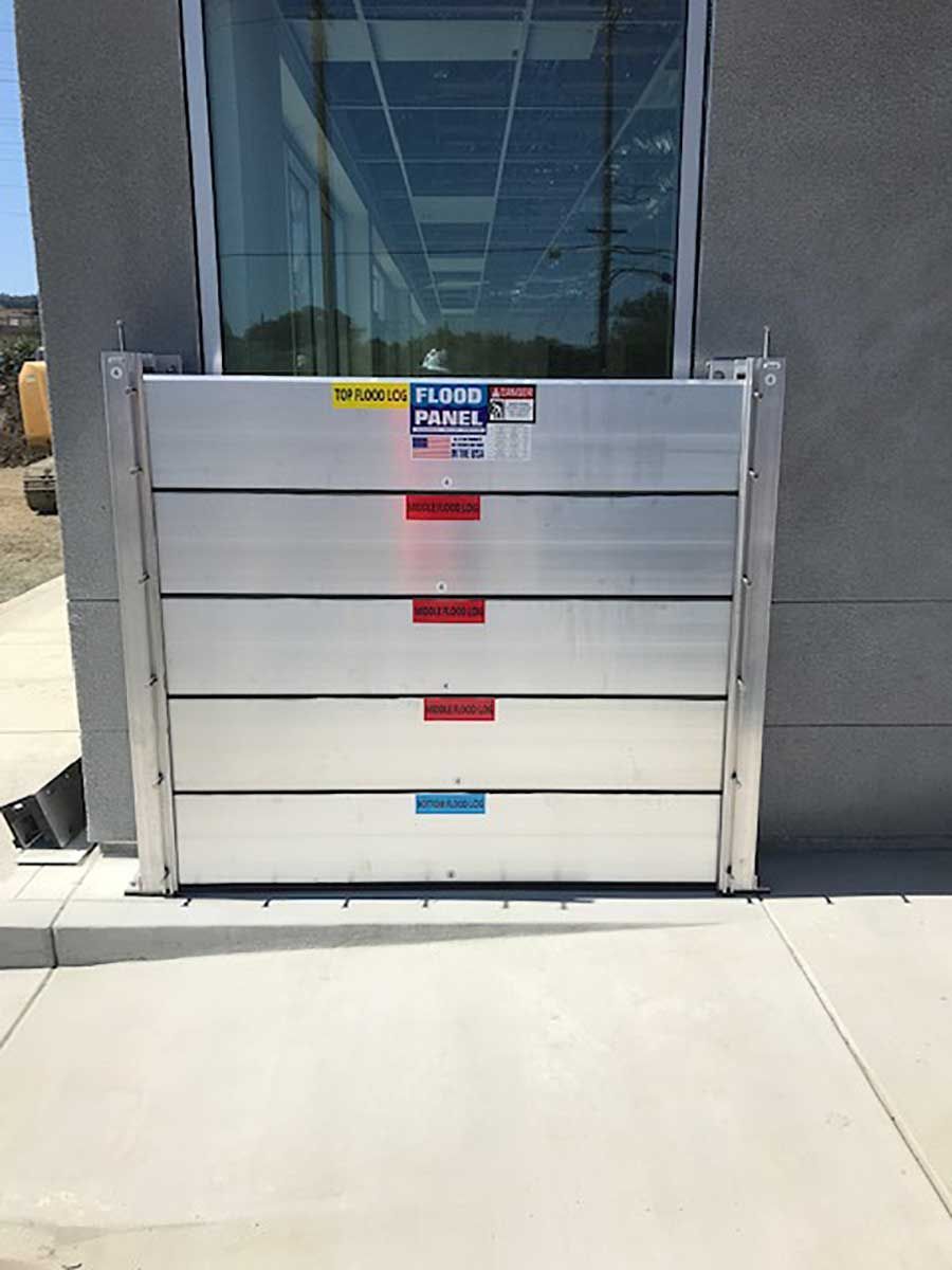 A flood barrier is sitting outside of a building next to a window.