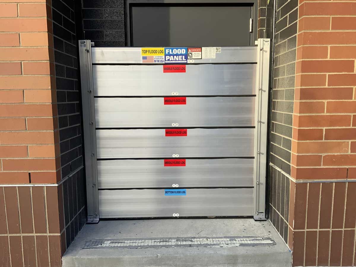 A stack of aluminum barriers against a brick wall