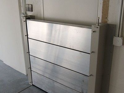 A stainless steel door is sitting on the side of a wall.