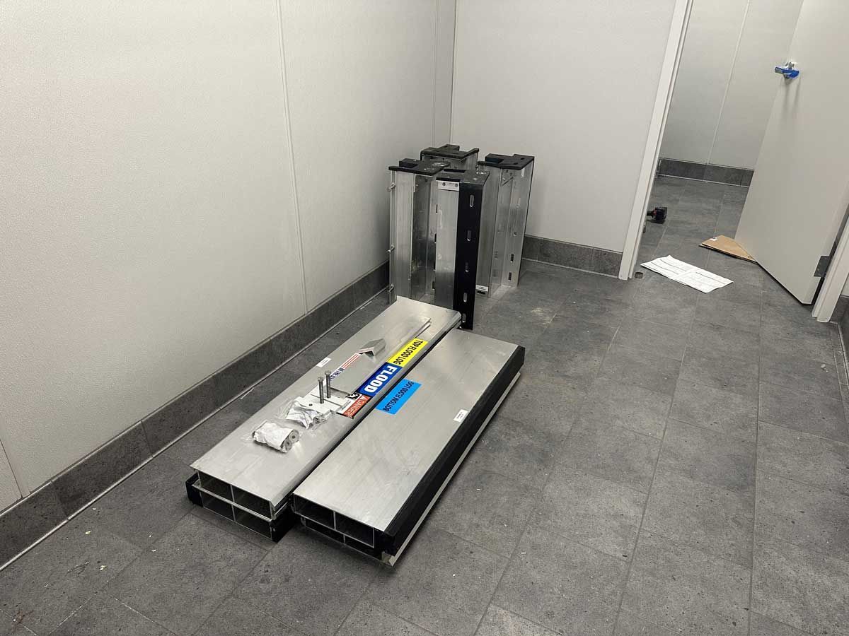 A room with a stack of metal pieces on the floor.