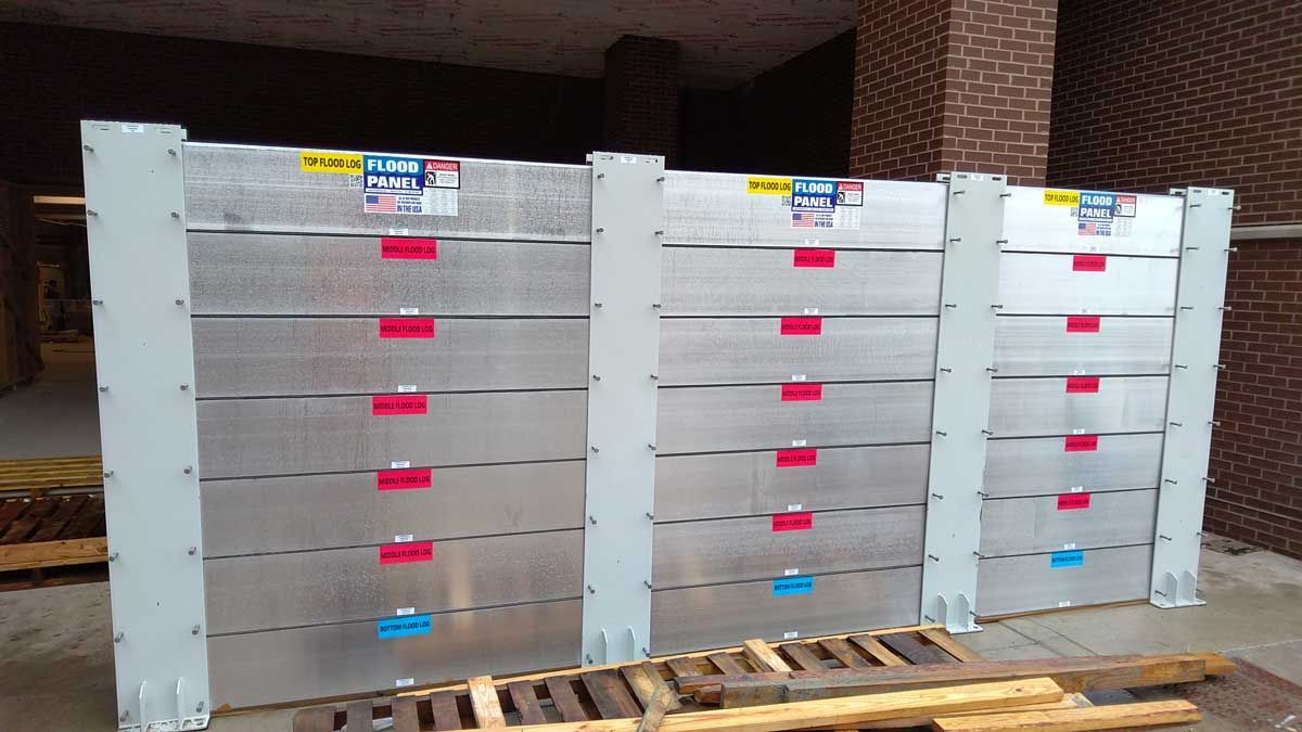 A row of aluminum barriers sitting on top of wooden pallets.