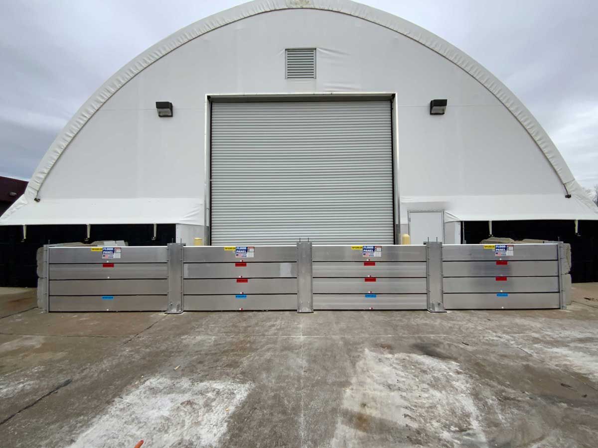 A large white building with a metal barrier in front of it