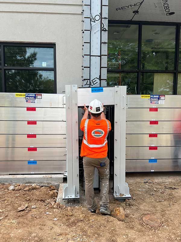 A man wearing an orange vest with the number 10 on it is standing in front of a building.
