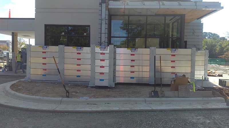 A building is being built next to a street with a fence.