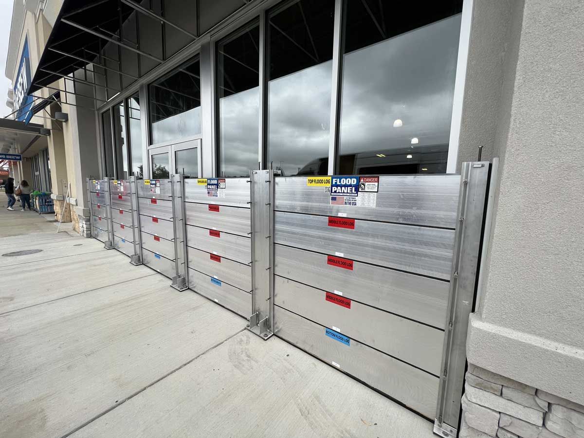 A building with a flood barrier on the sidewalk in front of it.