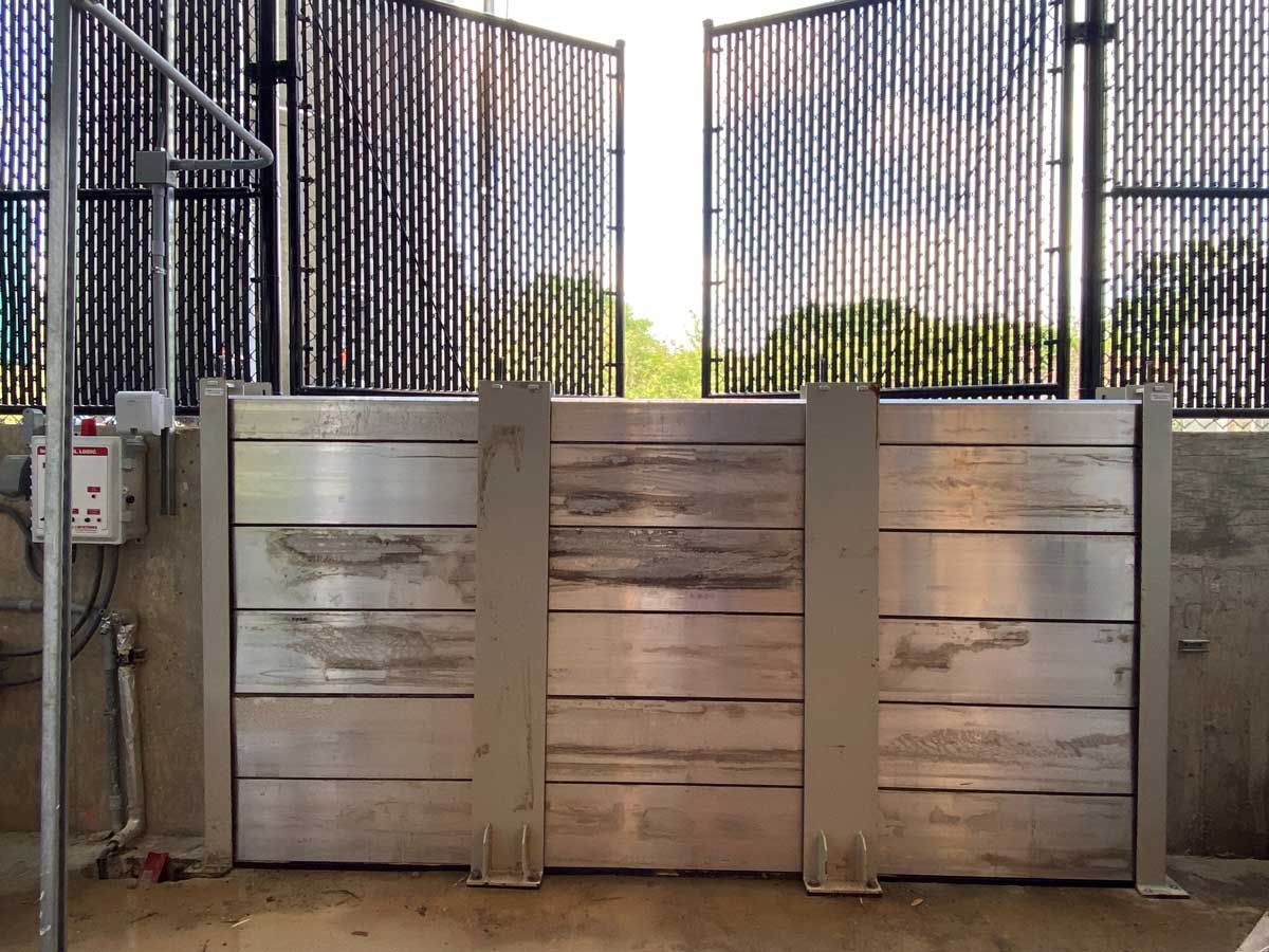 A metal gate is sitting in front of a fence.