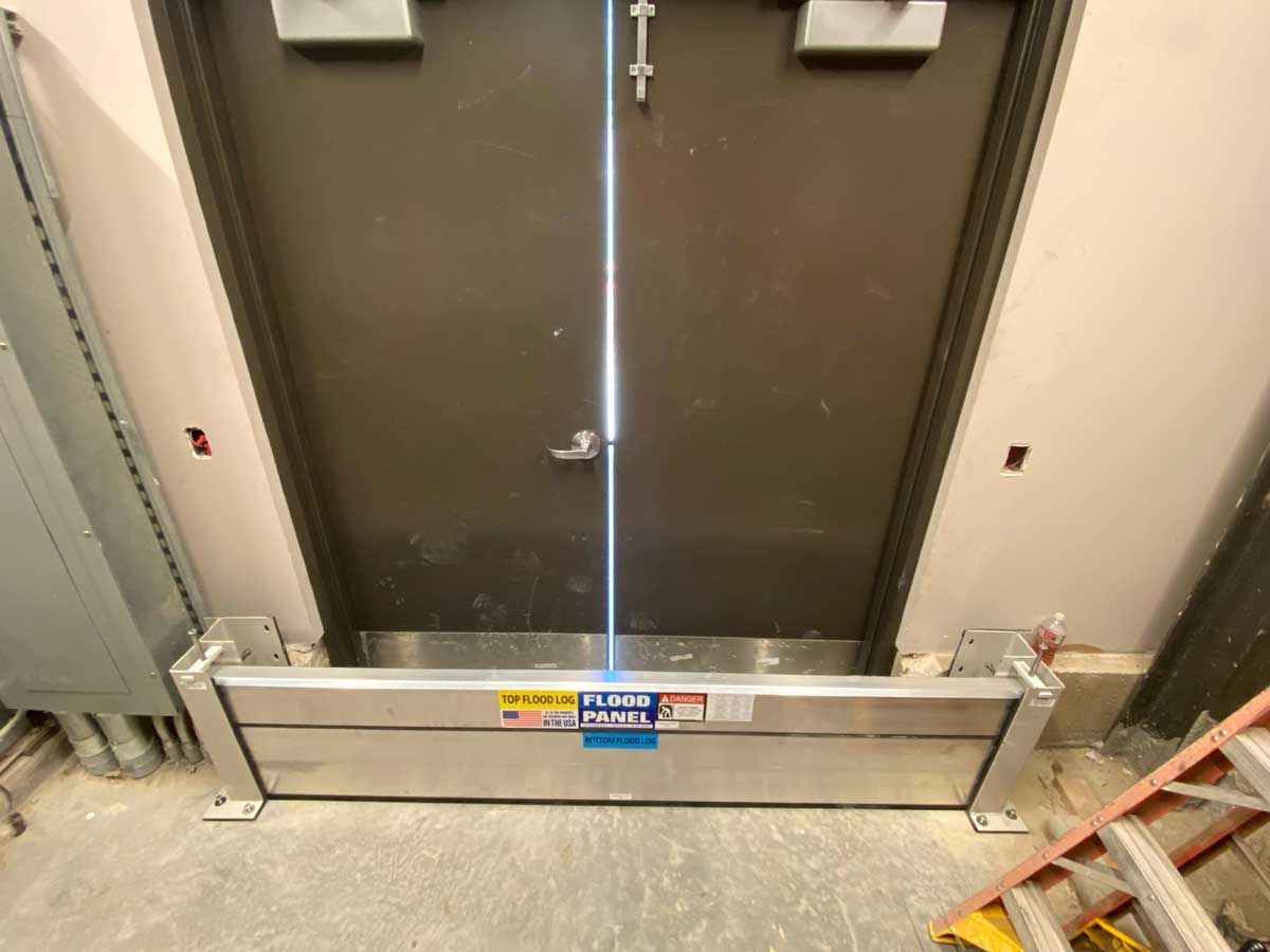 A door with a metal barrier between it and a wall.