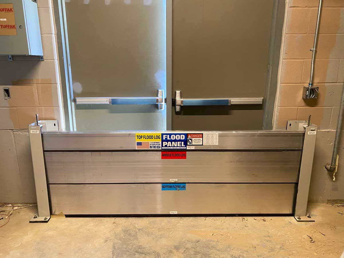 A flood barrier is sitting in front of a door in a room.