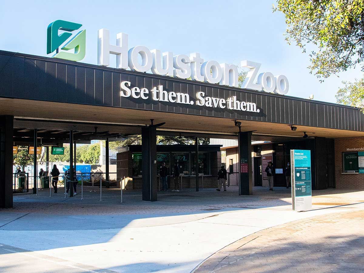 The entrance to the houston zoo has a sign that says `` see them , save them ''.