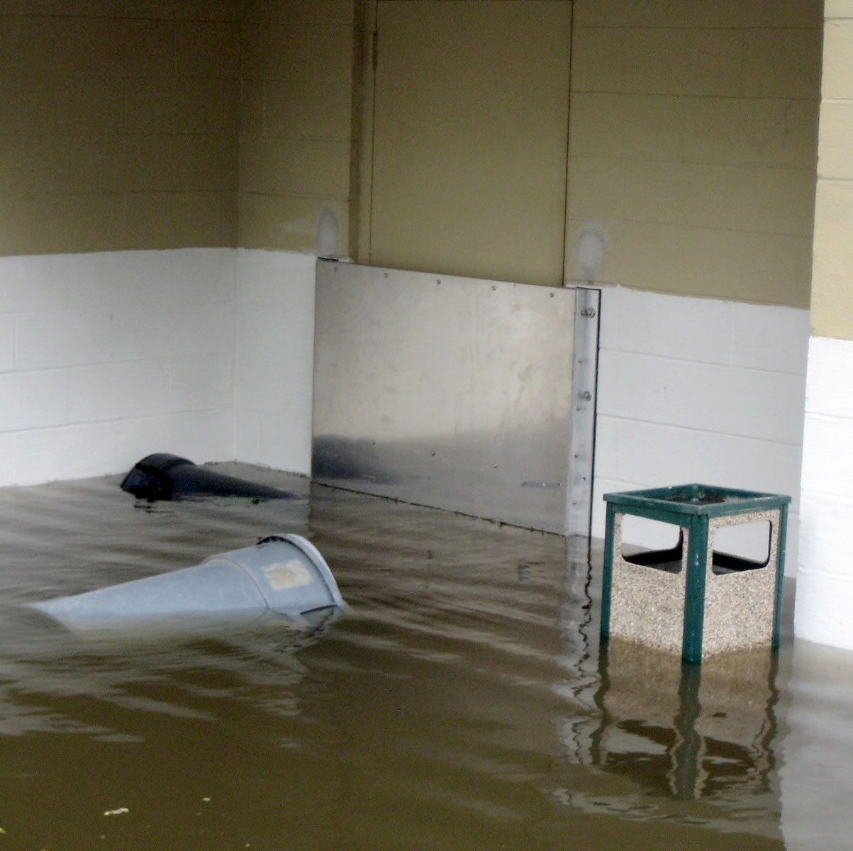 A bucket is floating in a flooded room