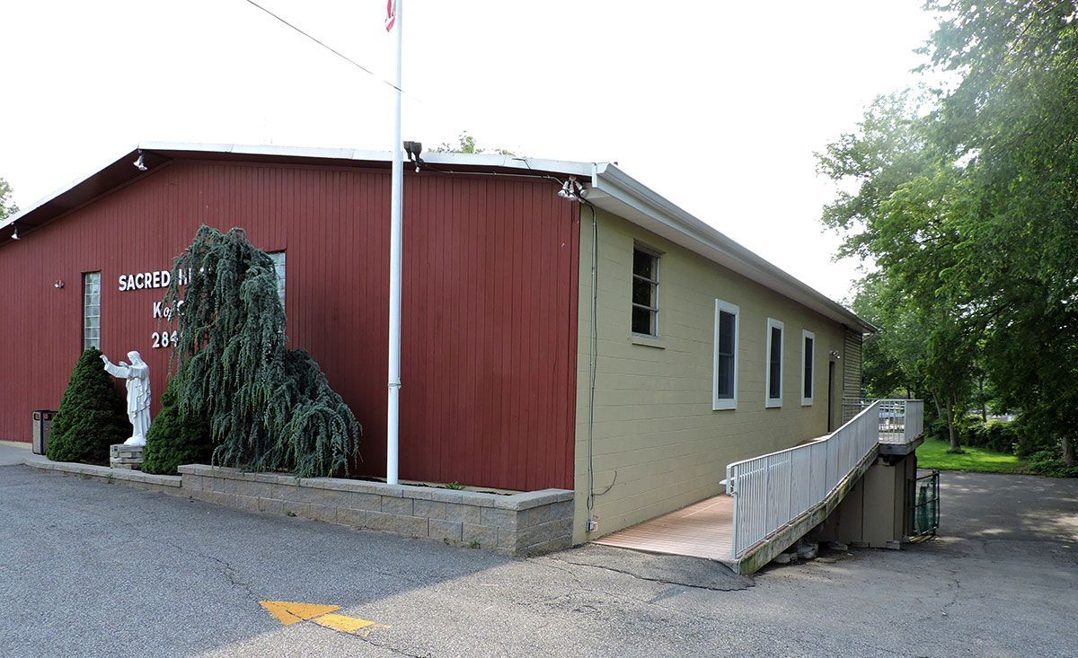 A large building with a red roof and a flag pole in front of it