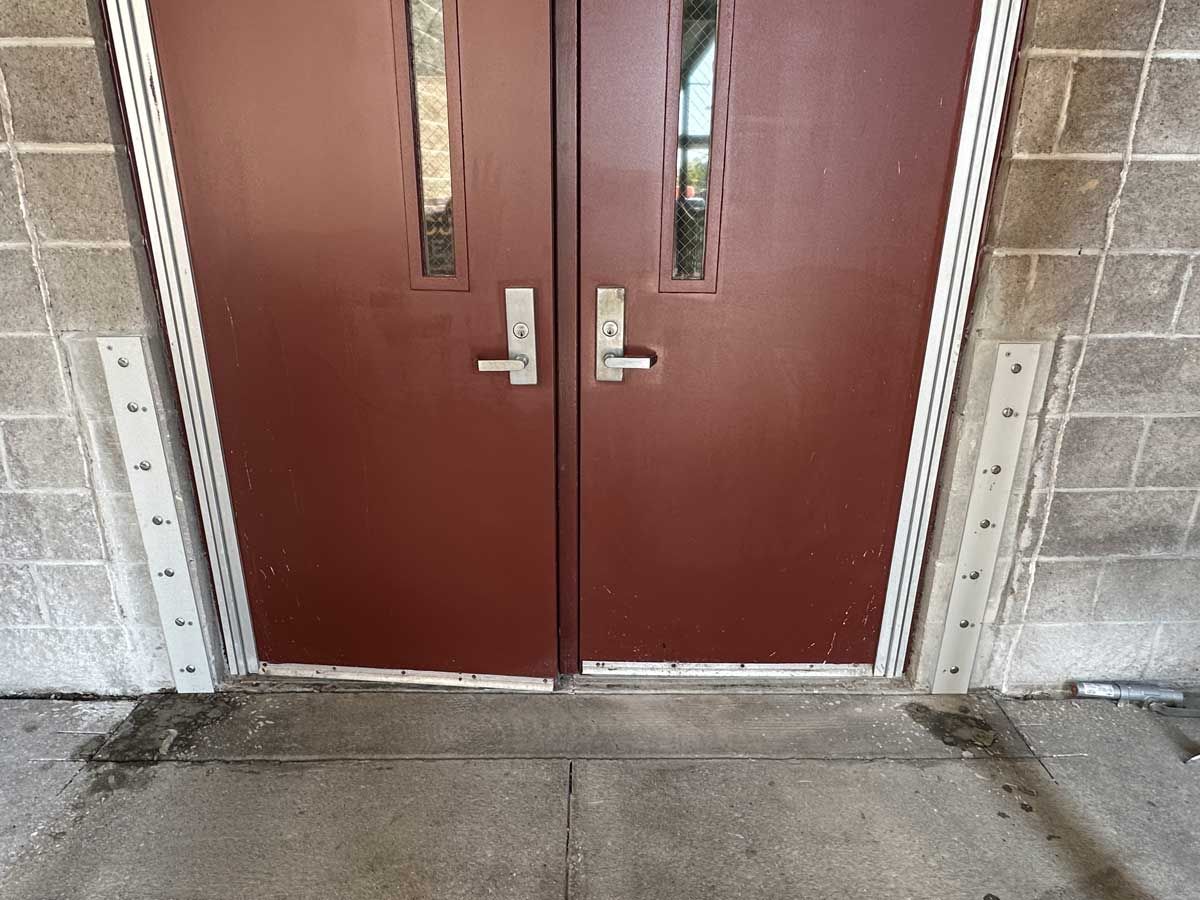 A close up of a pair of red doors on a brick building.