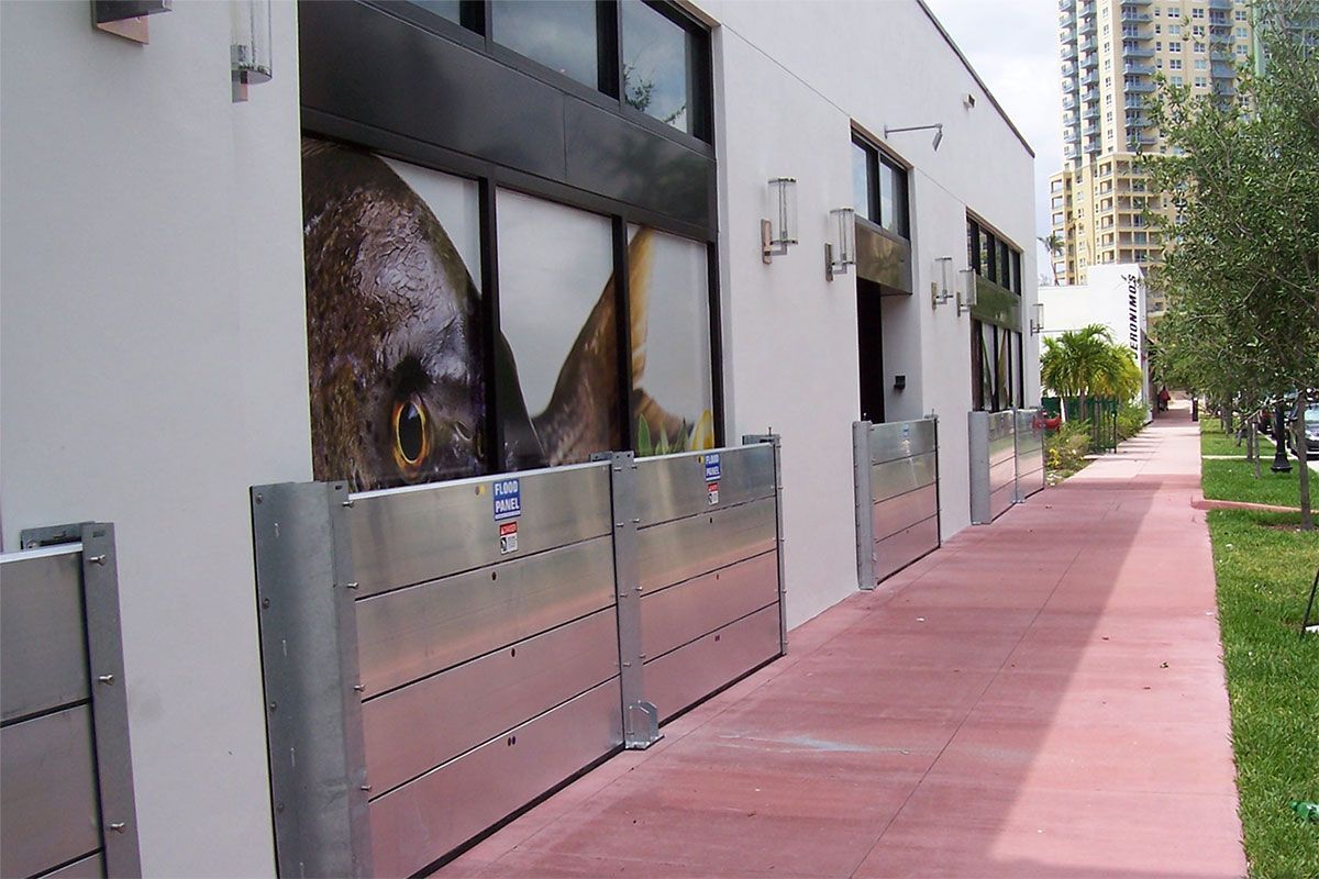 A sidewalk leading to a building with flood barriers on it