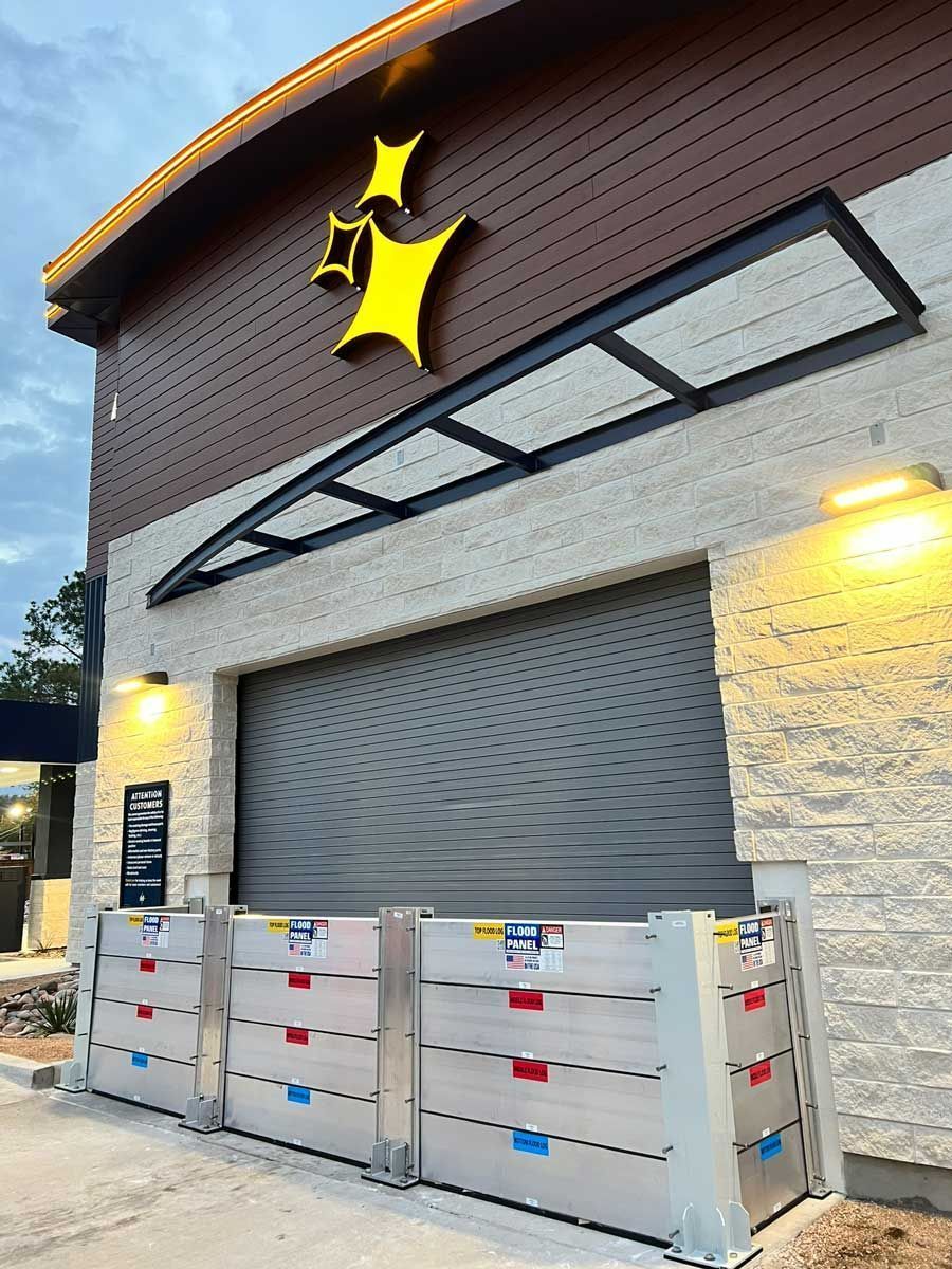 A building with a sign on the side of it and flood barriers in front of it.