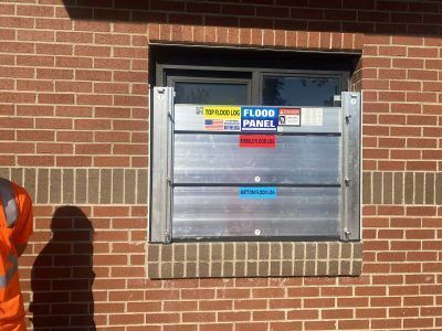 A man is standing in front of a window with a flood panel on it.