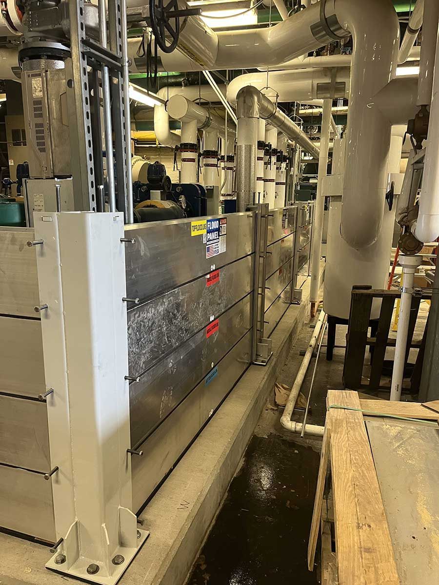 A large room with a lot of pipes and a wooden box in the middle.