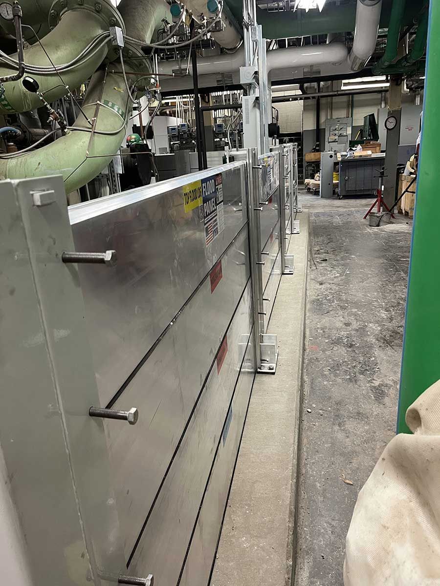 A person is standing next to a metal wall in a factory.