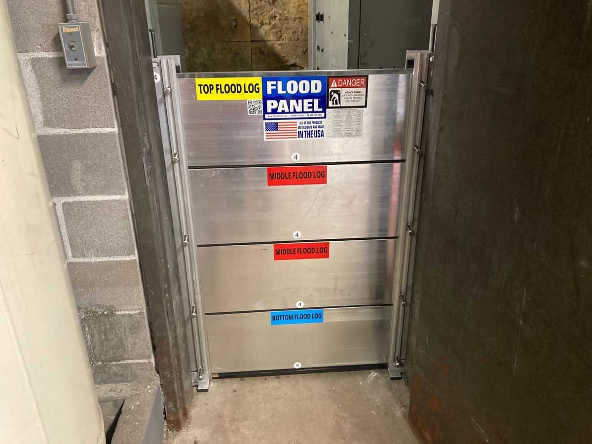 A flood panel is sitting in a doorway next to a brick wall.