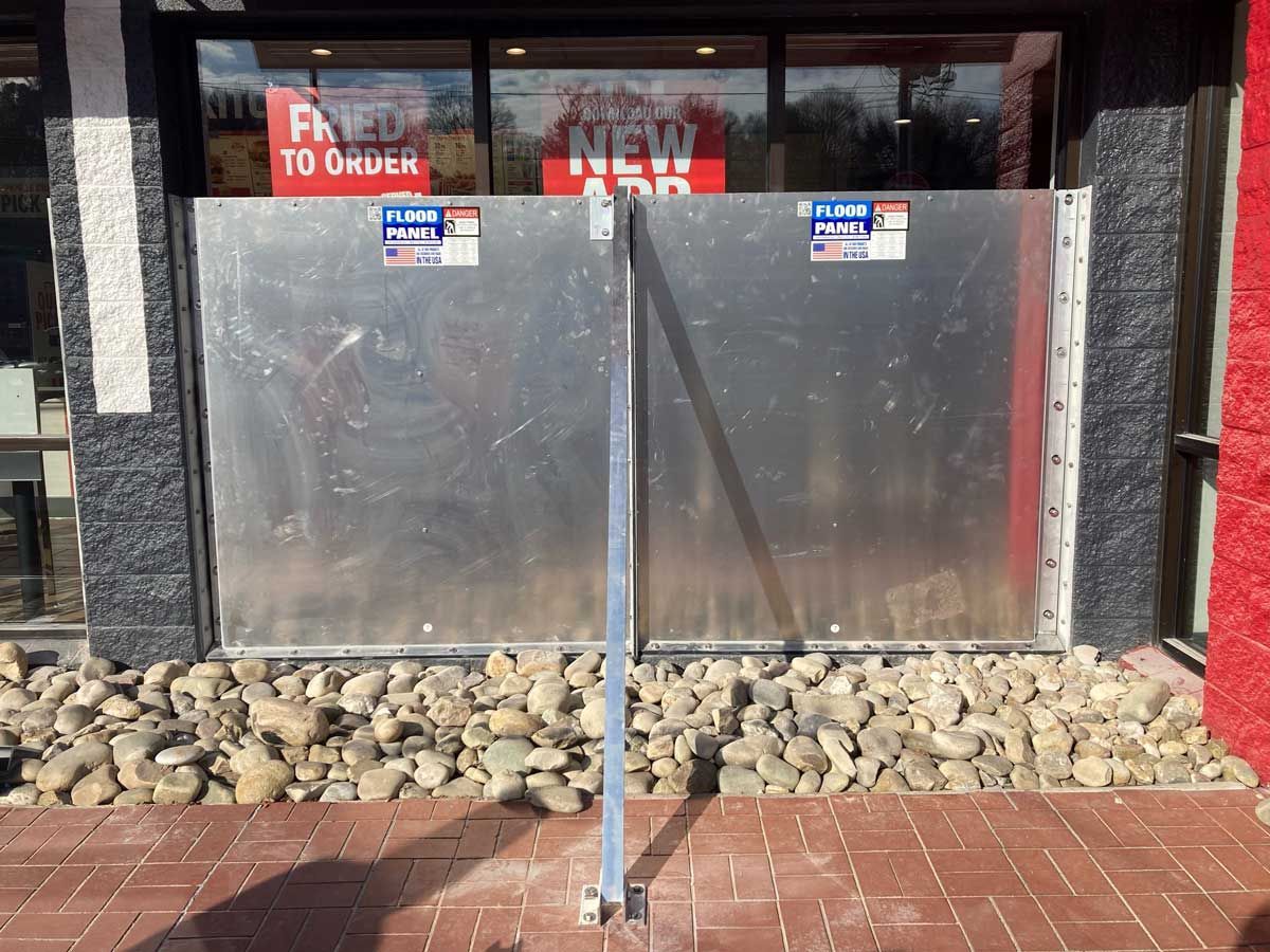 A flood barrier is sitting in front of a restaurant.