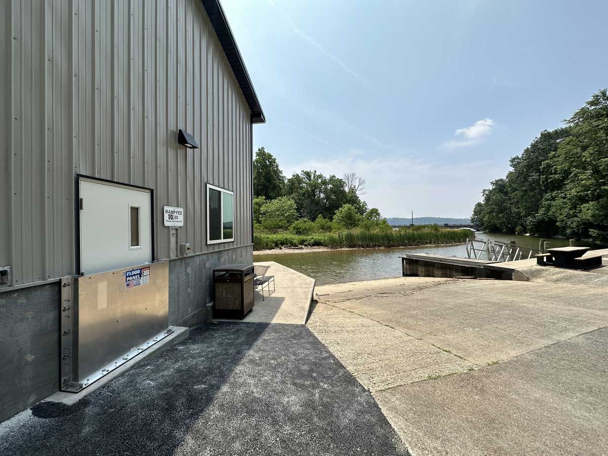 A building with a white door is next to a body of water.