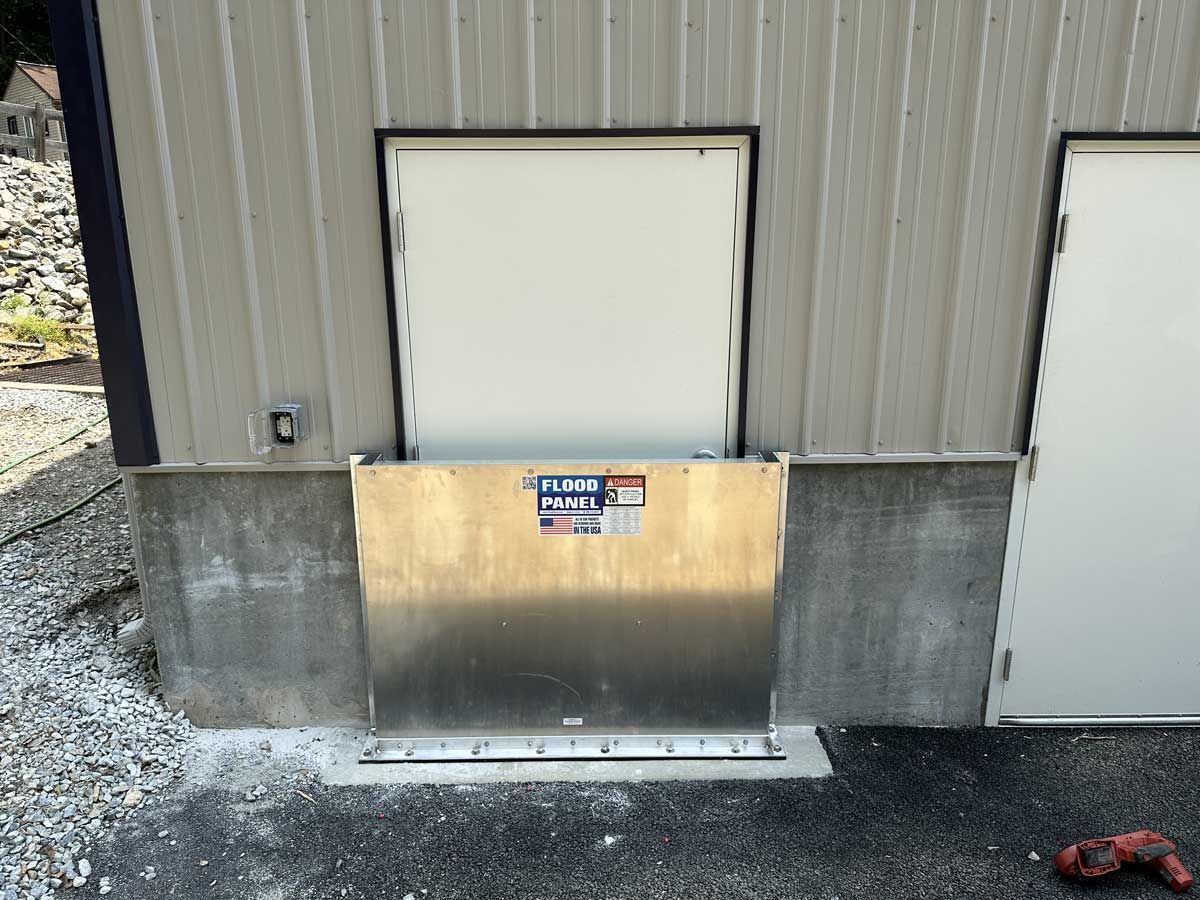 A metal barrier is sitting on the side of a building next to a door.