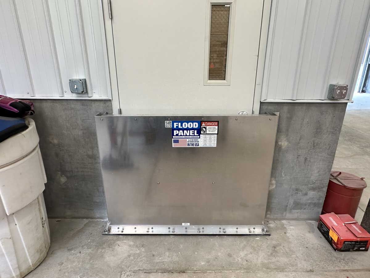 A stainless steel door barrier is sitting next to a door in a building.