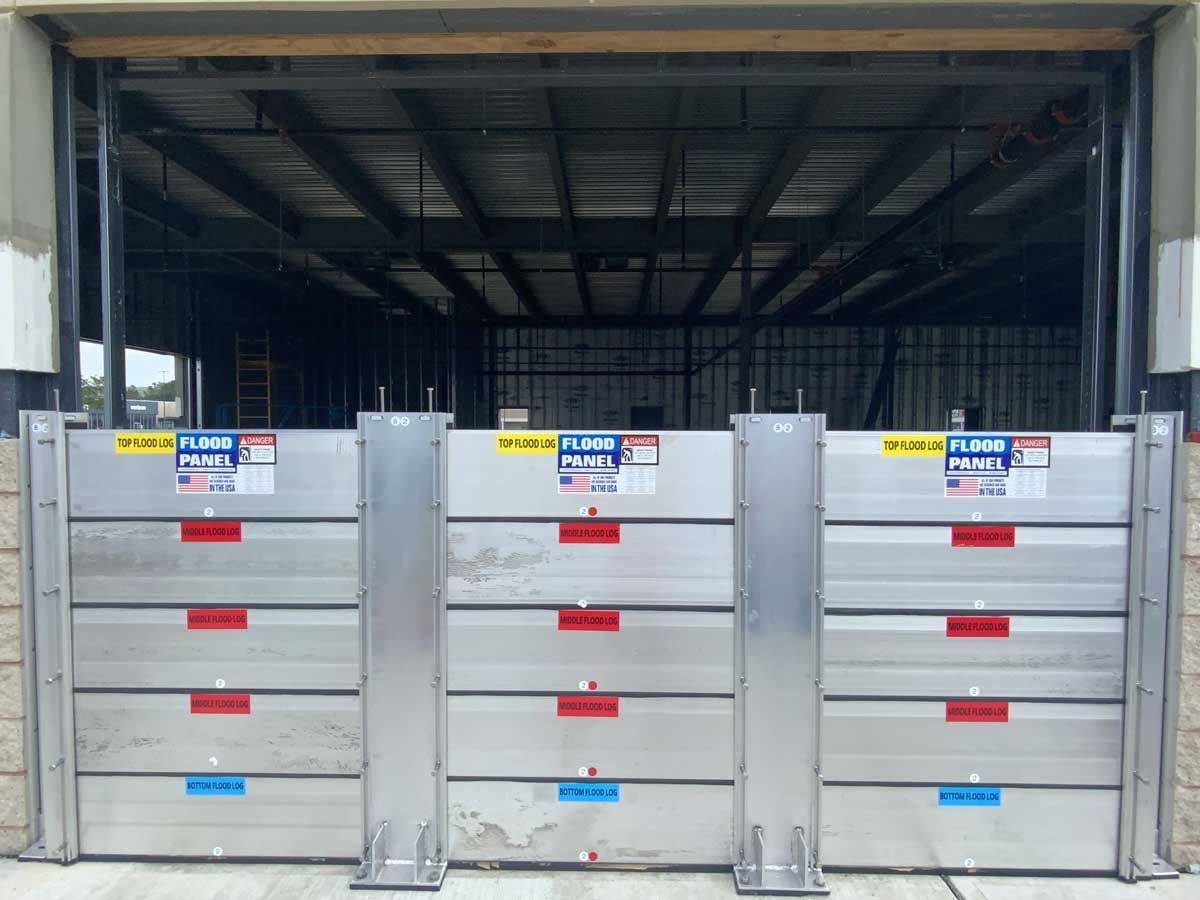 A row of flood barriers in front of a building under construction