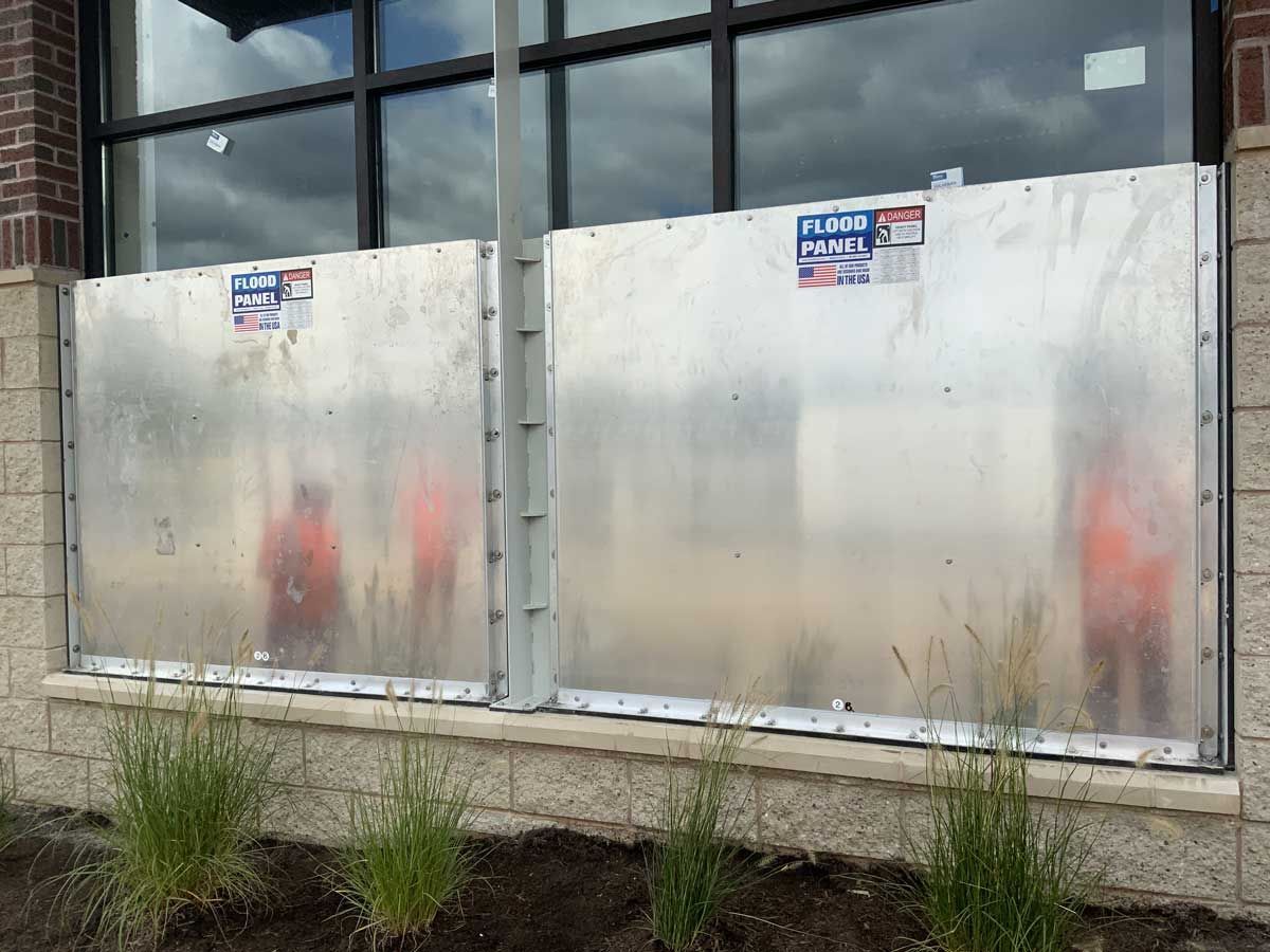 A metal barrier is being installed on the side of a building.