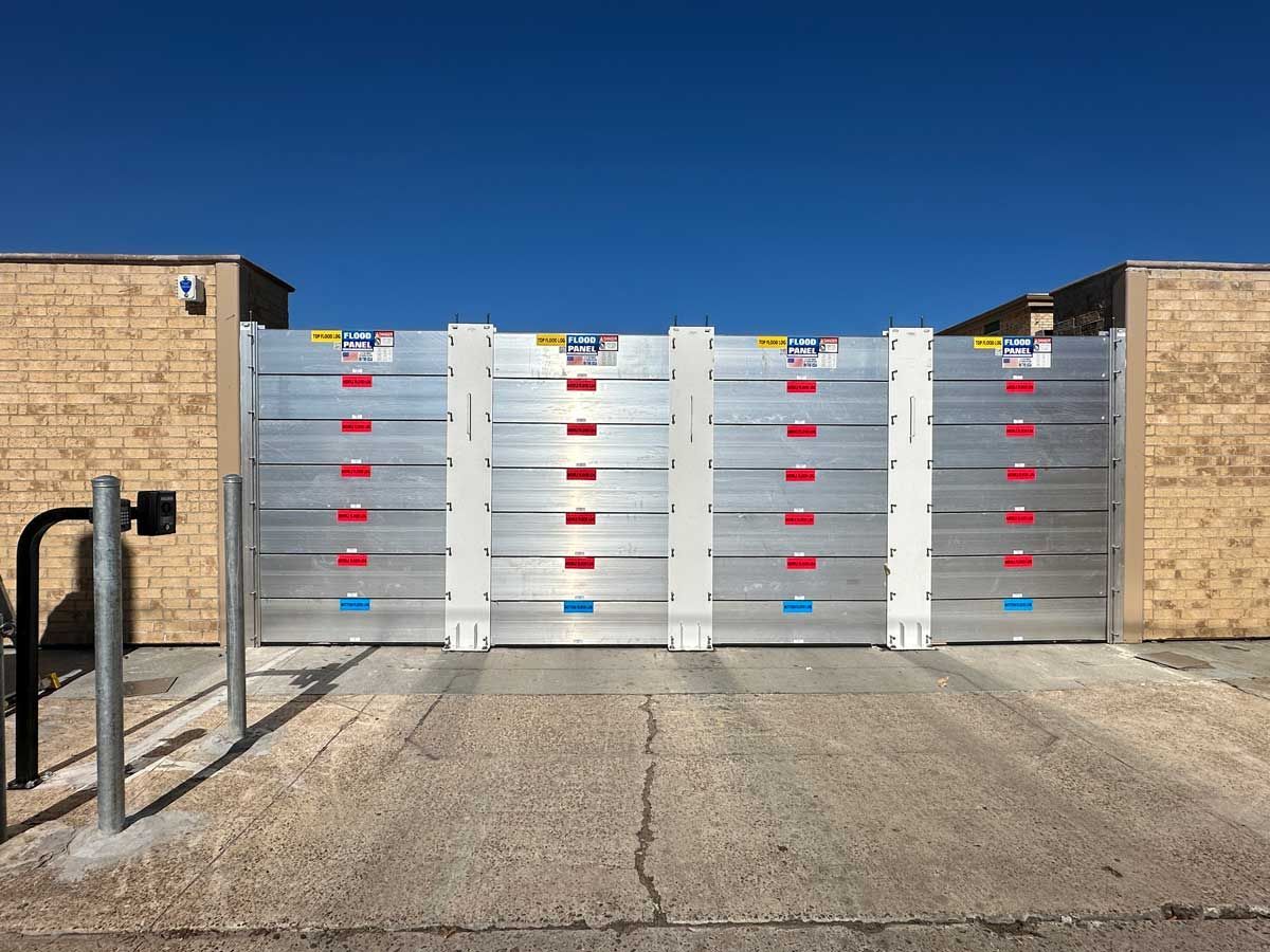 A metal gate is sitting in front of a brick building.