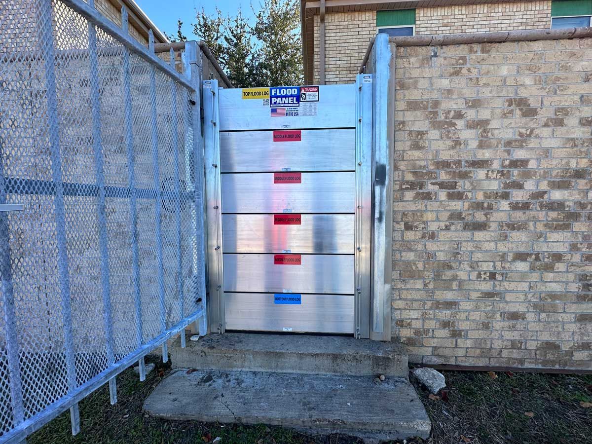 A metal gate is sitting in front of a brick wall.