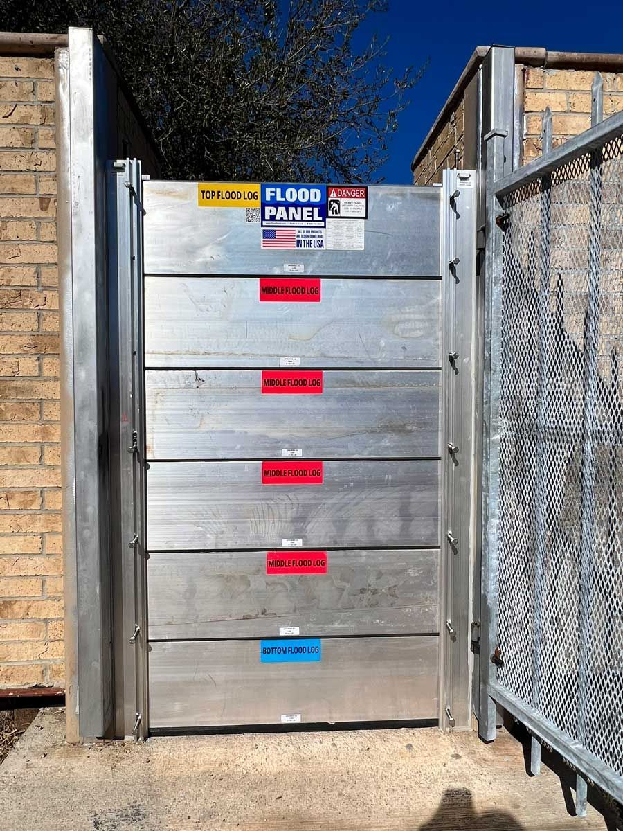 A metal gate with a brick wall in the background.