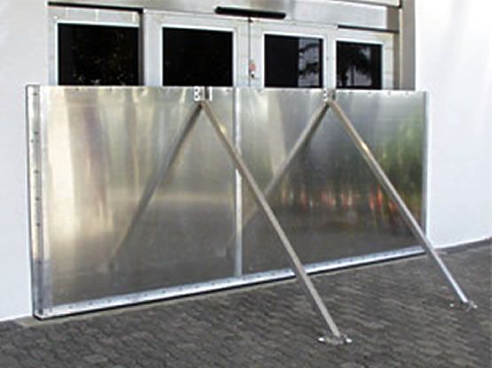 A stainless steel barrier is attached to the side of a building