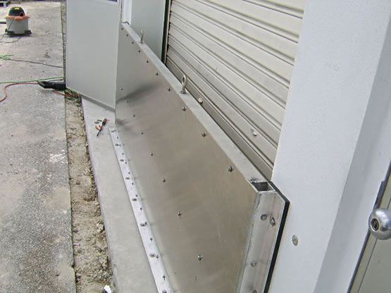 A stainless steel barrier is being installed on the side of a building.