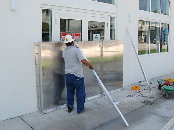 A man wearing a hard hat is working on a door