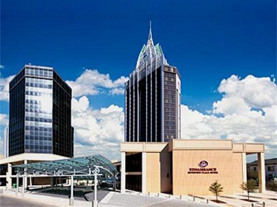 A large building with a blue sky and clouds in the background