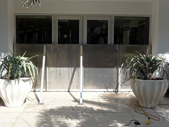 A row of potted plants are sitting in front of a building.