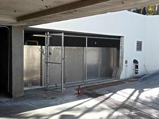 There is a fire hydrant in front of a chain link fence.