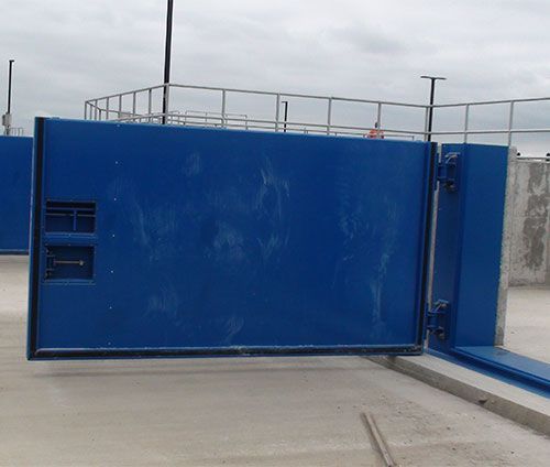 A blue sliding gate is open to a concrete area