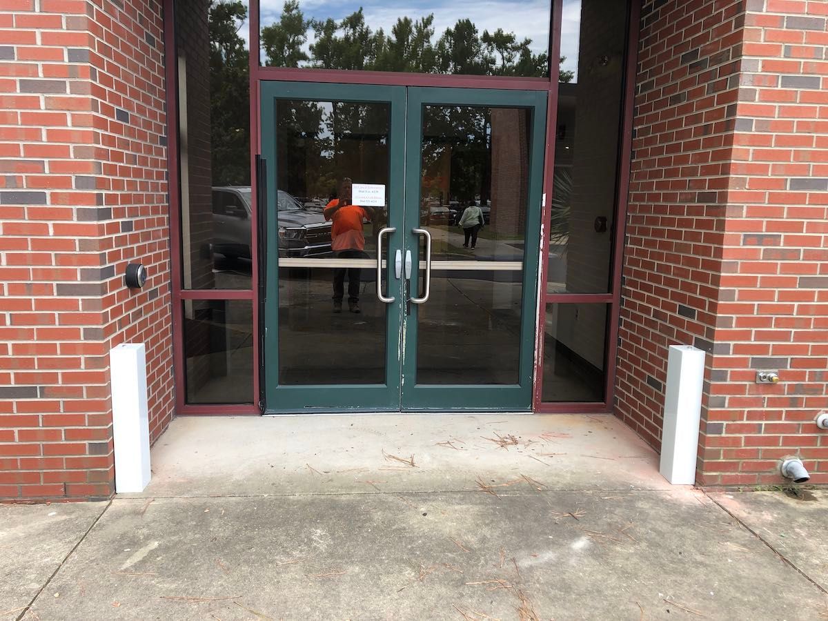 A brick building with a green door and glass windows